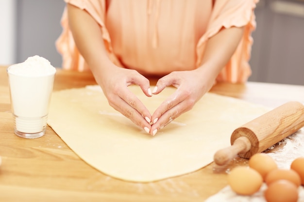 Mujer joven tratando de cocinar algo en la cocina