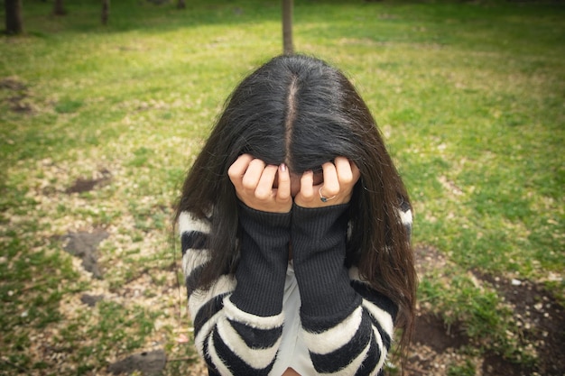 Mujer joven triste y deprimida en el parque