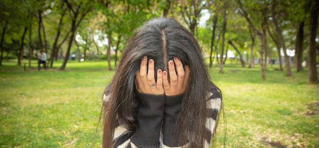 Mujer joven triste y deprimida en el parque