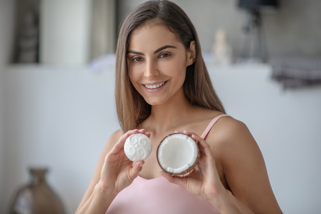 Mujer joven tryng un nuevo jabón con aceite de coco