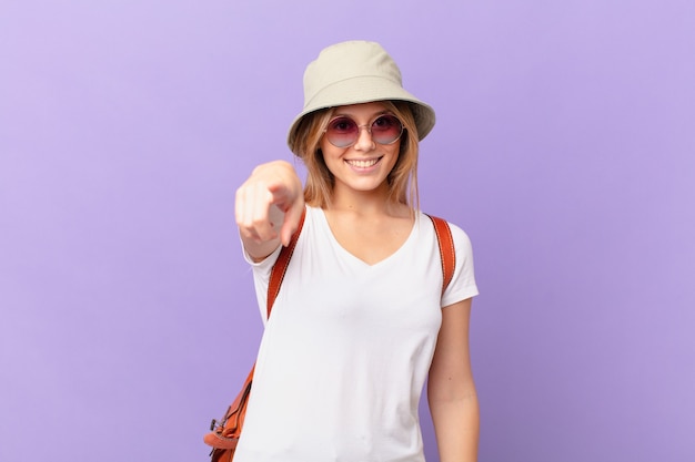 Mujer joven turista apuntando al frente eligiéndote