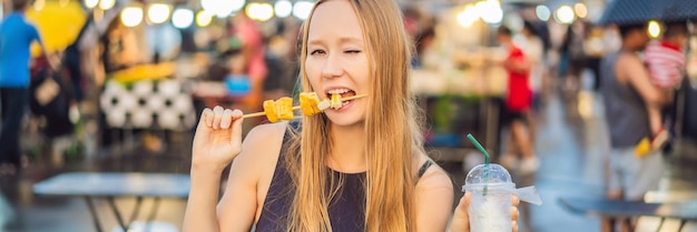 Mujer joven turista en la calle peatonal mercado de comida asiática banner formato largo