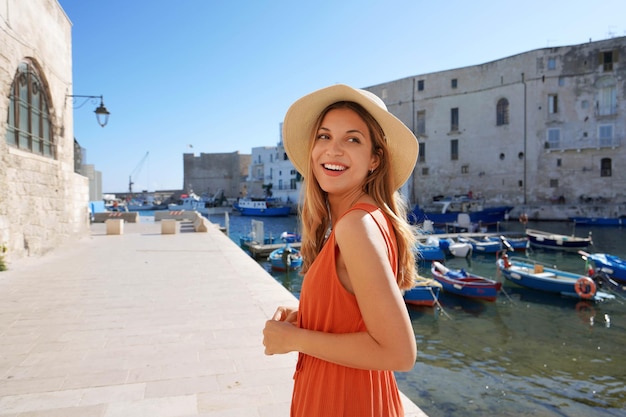 Mujer joven turista en la ciudad antigua y el puerto de Monopoli Apulia Italia