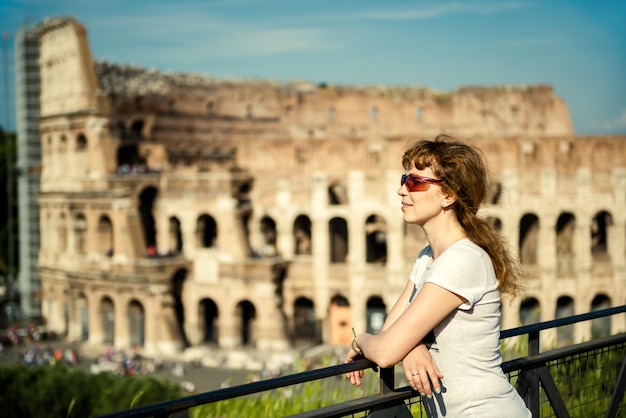 Mujer joven turista en el fondo del Coliseo Roma Italia