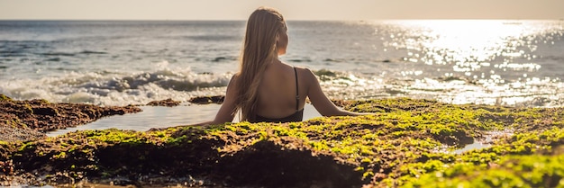 Mujer joven turista en pantai tegal wangi beach sentado en un baño de agua de mar isla de bali indonesia