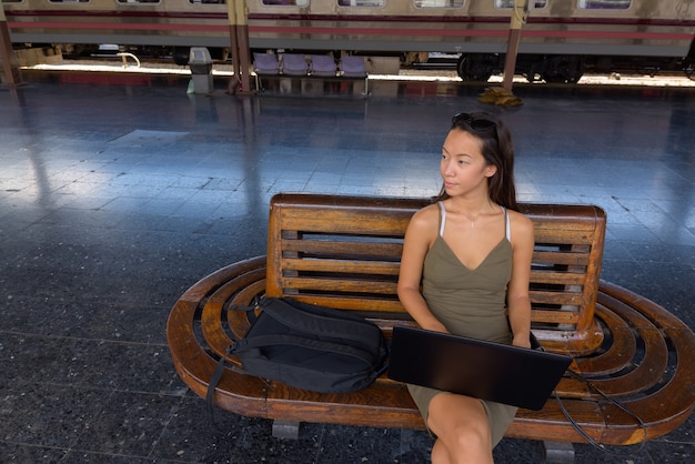 Mujer joven turista sentado y usando la computadora portátil