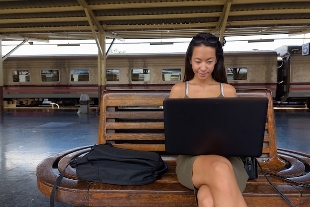 Mujer joven turista sentado y usando la computadora portátil