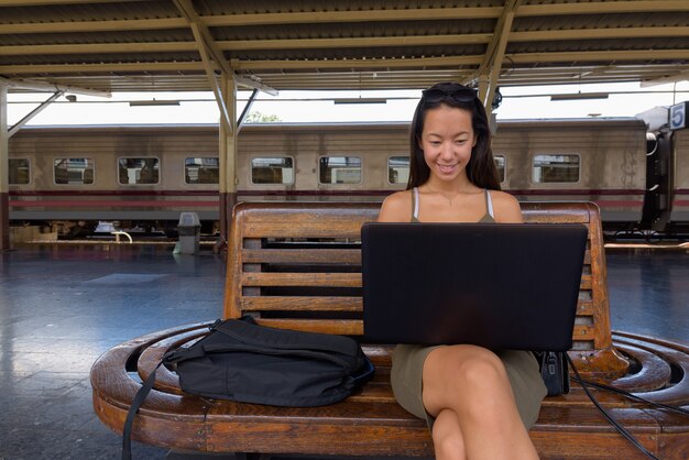 Mujer joven turista sentado y usando la computadora portátil