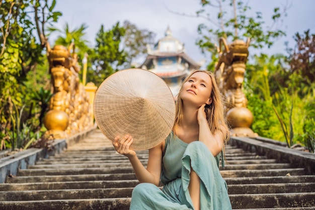 Foto mujer joven turista en un sombrero vietnamita tradicional viaja a vietnam