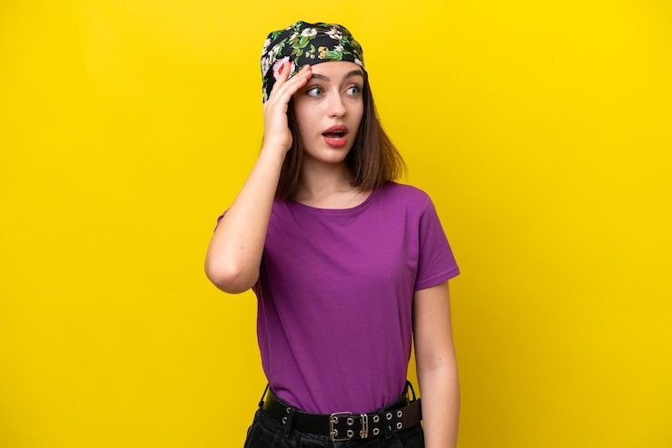 Foto mujer joven ucraniana aislada en fondo amarillo con expresión de sorpresa mientras mira hacia el lado