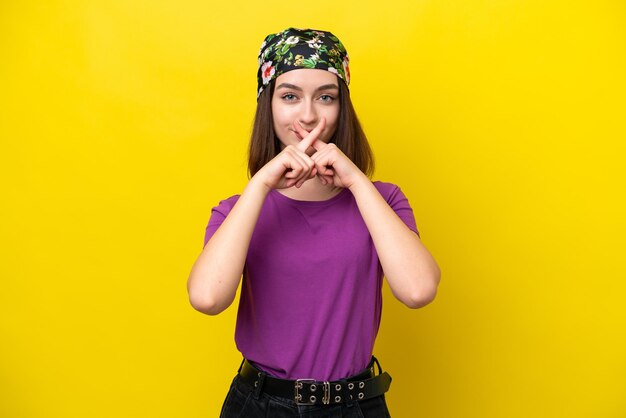 Foto mujer joven ucraniana aislada sobre un fondo amarillo mostrando un gesto de silencio