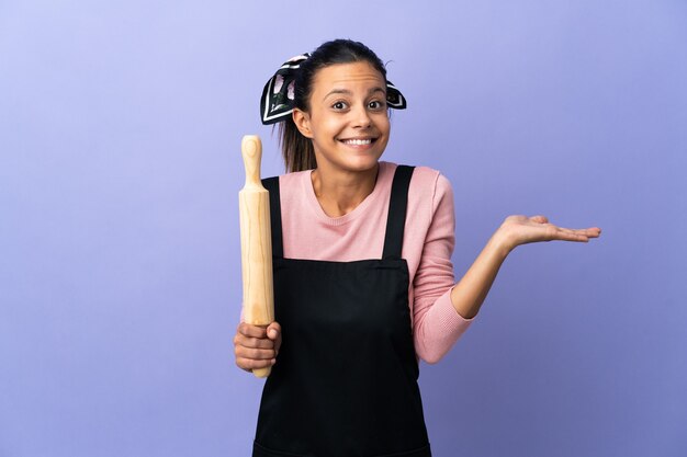 Mujer joven en uniforme de chef con dudas mientras levanta las manos