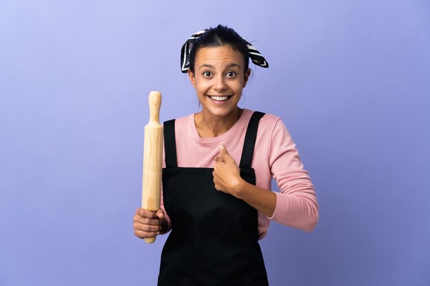 Mujer joven en uniforme de chef con expresión facial sorpresa