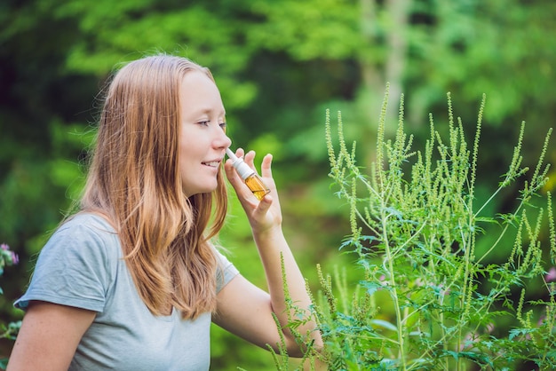 Foto mujer joven usa un aerosol de una alergia debido a una alergia a la ambrosía