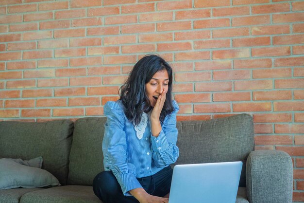 Foto mujer joven usando una computadora en casa