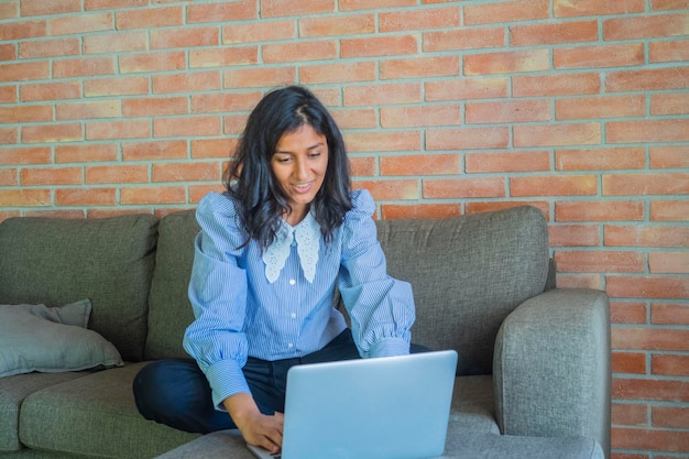 Foto mujer joven usando una computadora en casa