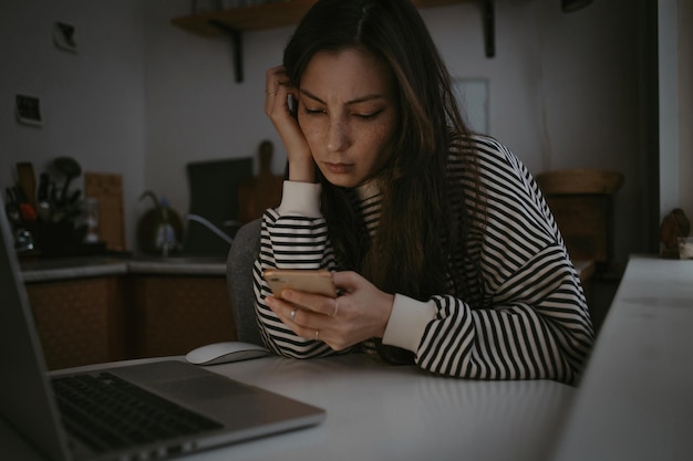 Mujer joven usando una computadora portátil en casa