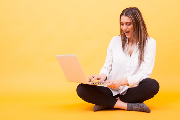 Foto mujer joven usando una computadora portátil en casa