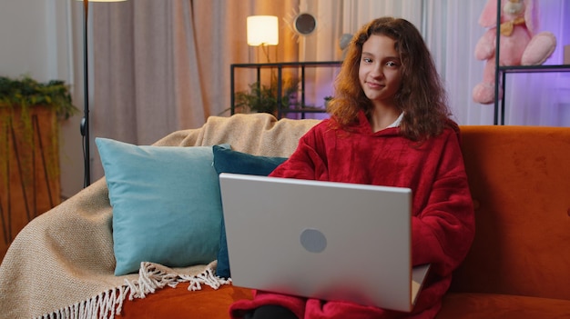 Mujer joven usando una computadora portátil en casa
