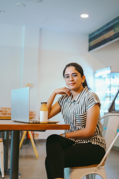 Mujer joven usando una computadora portátil en casa