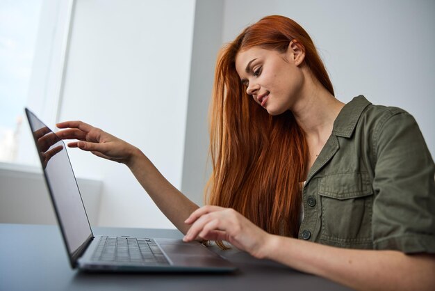 Mujer joven usando una computadora portátil en casa