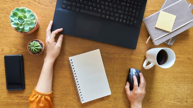 Foto mujer joven usando una computadora portátil en un escritorio de madera