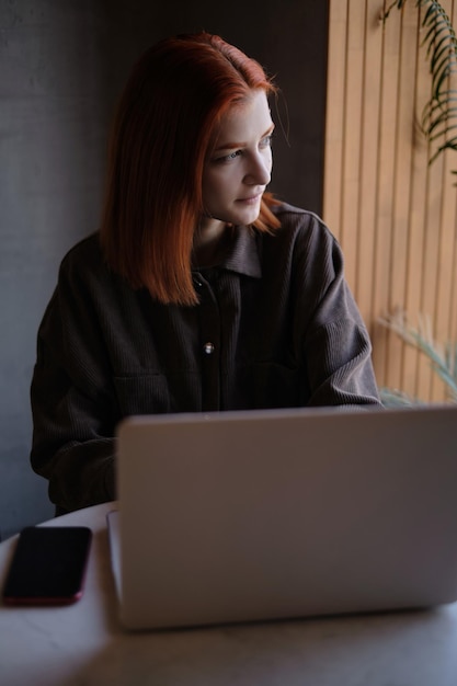 Mujer joven usando computadora portátil en la mesa