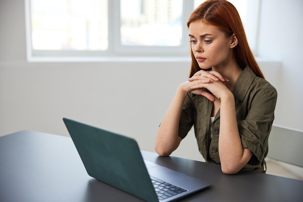 Mujer joven usando computadora portátil en la mesa