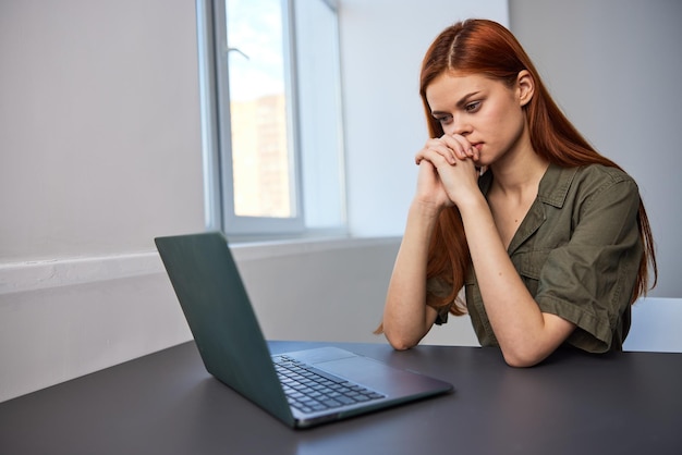 Mujer joven usando computadora portátil en la mesa