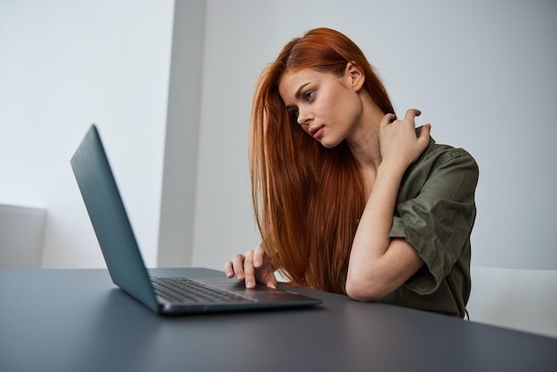 Mujer joven usando computadora portátil en la mesa