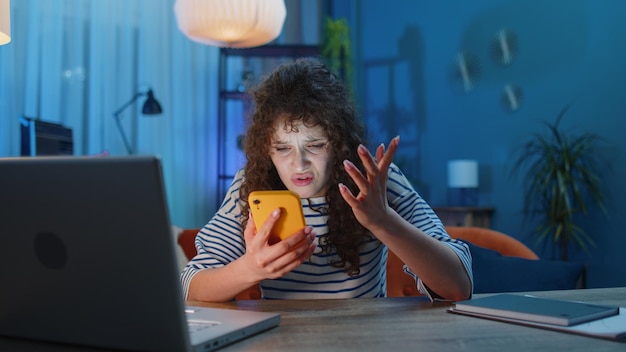 Mujer joven usando una computadora portátil mientras está sentada en la mesa
