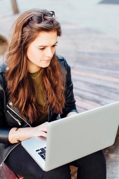 Una mujer joven usando una computadora portátil en la pasarela.