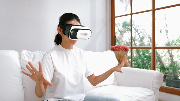 Mujer joven usando gafas de realidad virtual en casa para la experiencia de vivacidad