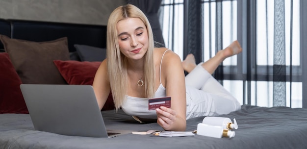 Mujer joven usando portátil con tarjeta de crédito para banca por Internet compras en línea comercio electrónico por puerta de entrada de pago en línea en la oficina de casa compra en línea moderna y conveniente Panorama Blithe