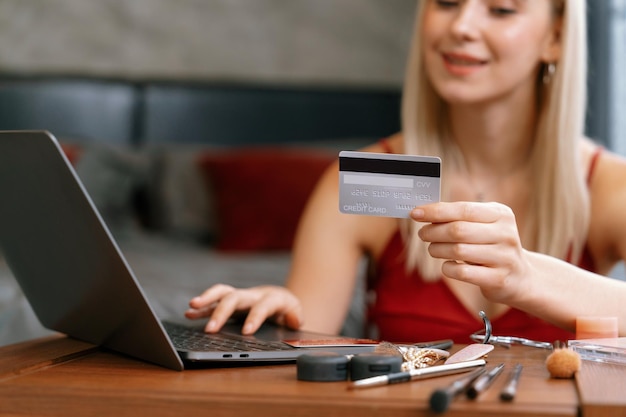 Mujer joven usando portátil con tarjeta de crédito para la banca por Internet