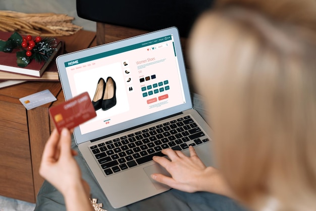 Mujer joven usando portátil con tarjeta de crédito para la banca por Internet