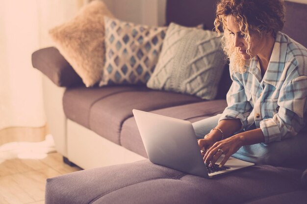 Mujer joven usando una tableta digital en casa