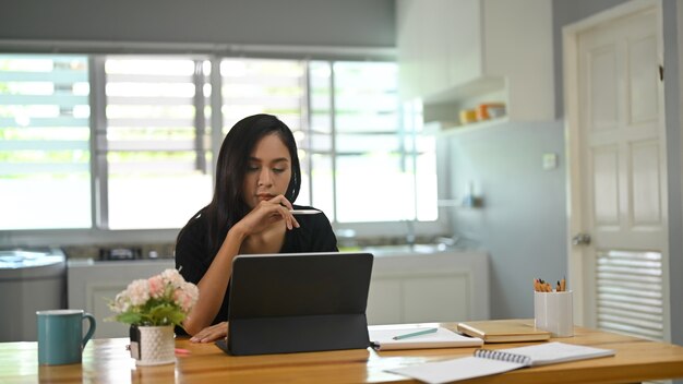 Mujer joven usando una tableta mientras está sentado