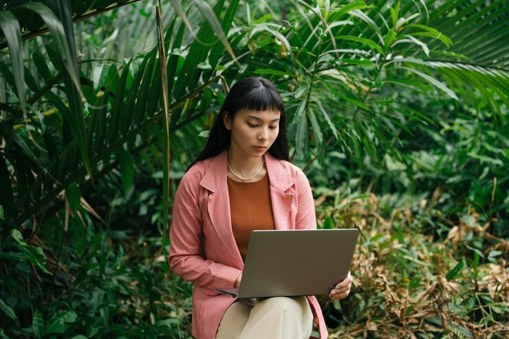 Foto mujer joven usando el teléfono mientras está de pie en las plantas