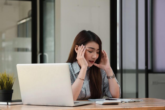 Mujer joven usando el teléfono mientras está sentada en la mesa