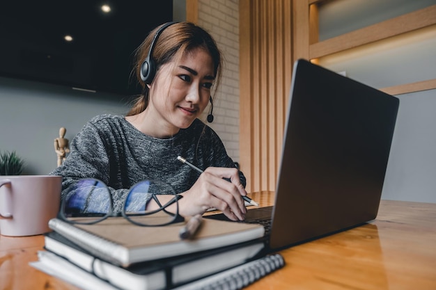 Mujer joven usando el teléfono mientras está sentada en la mesa
