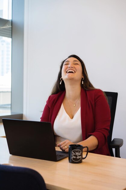 Foto mujer joven usando el teléfono mientras está sentada en la mesa