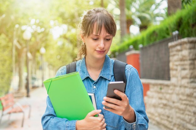 Foto mujer joven usando el teléfono móvil al aire libre