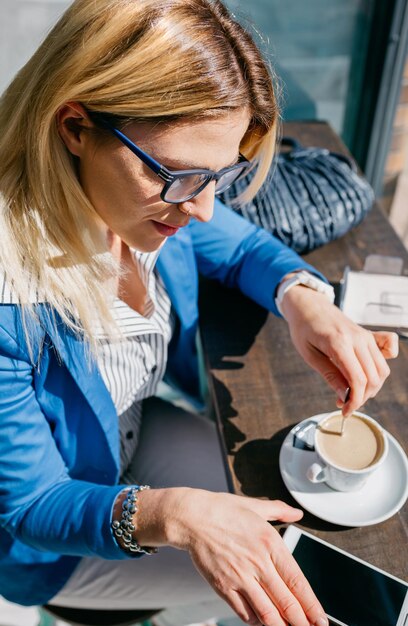 Foto mujer joven usando teléfono móvil en un café