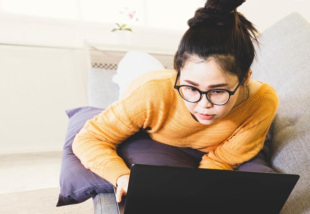 Mujer joven usando teléfono móvil en casa