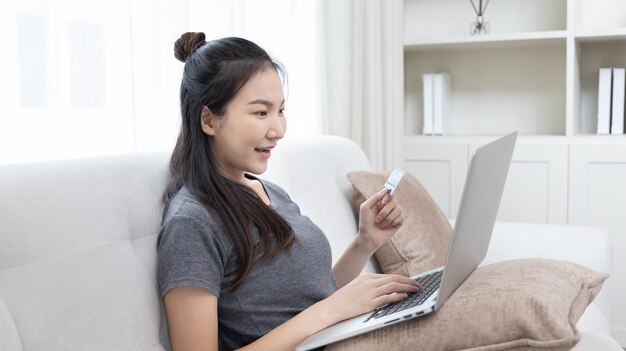 Mujer joven usando teléfono móvil en casa