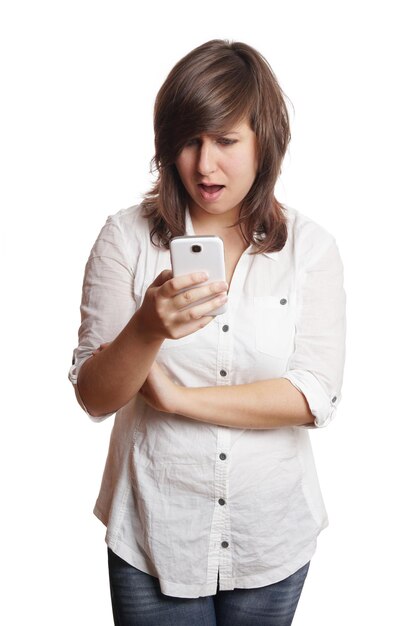 Mujer joven usando teléfono móvil contra un fondo blanco