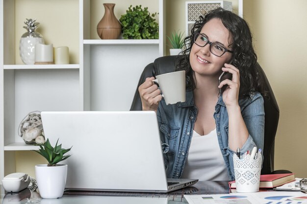 Foto mujer joven usando teléfono móvil en la mesa