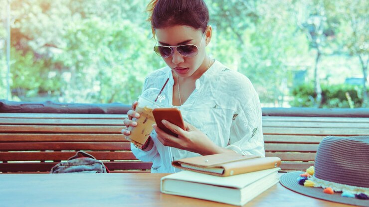 Foto mujer joven usando teléfono móvil en la mesa