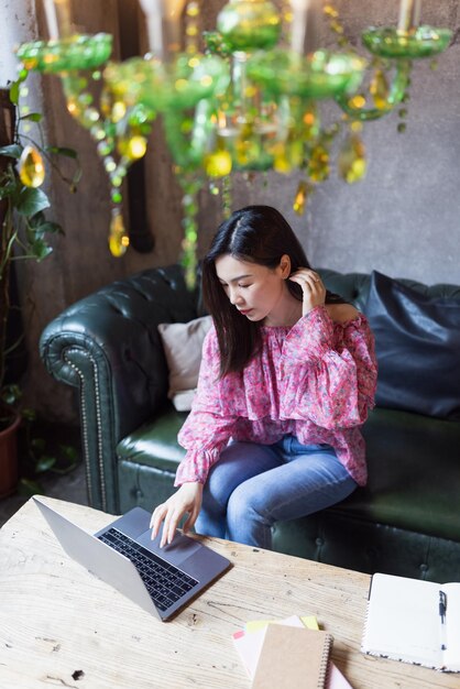 Mujer joven usando teléfono móvil mientras está sentada al aire libre